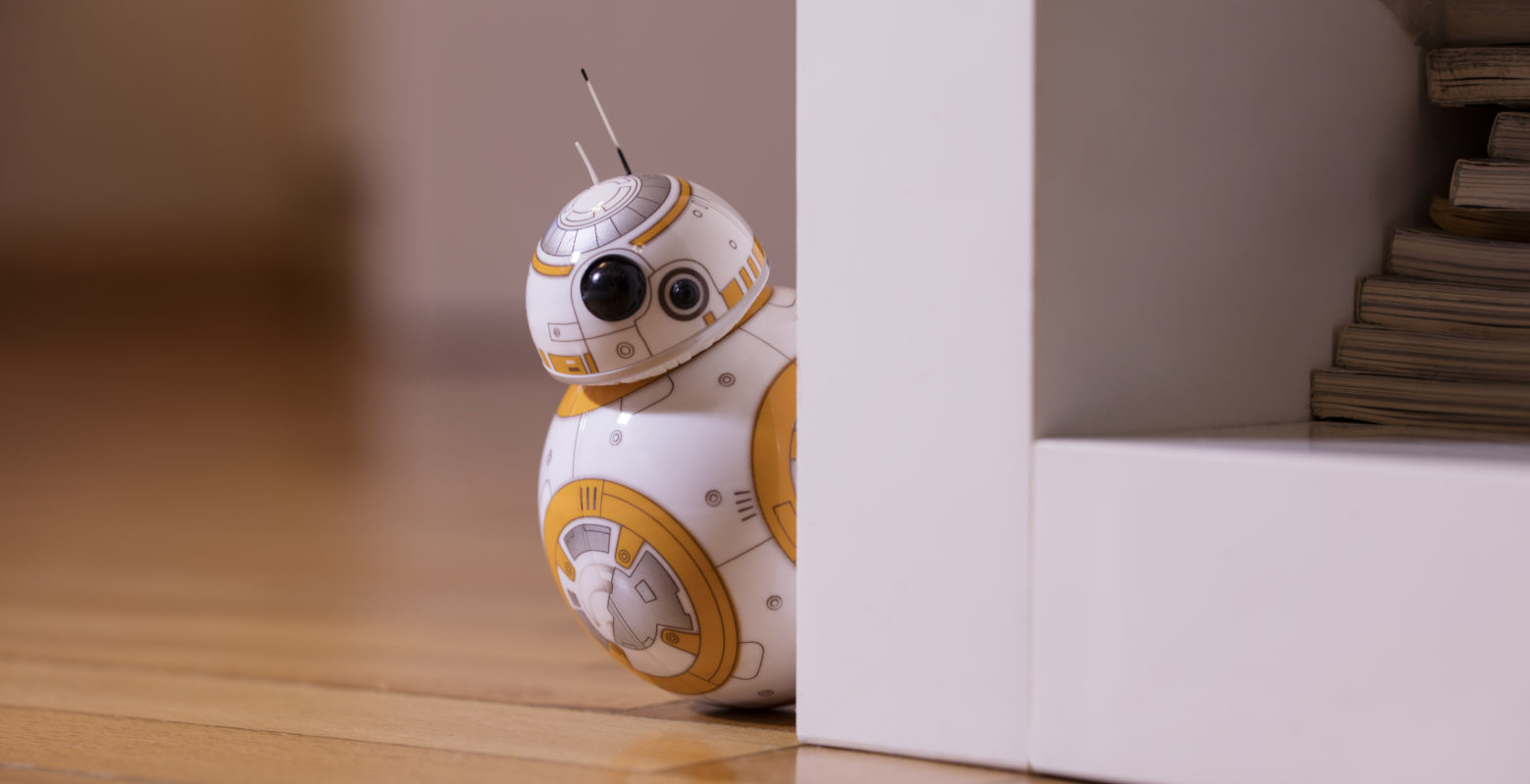 ?stanbul, Turkey - December 12, 2015: Portrait of BB-8 toy hiding behind a bookshelf. New droid of Star Wars movie appearing in The Force Awakens episode. BB-8 toy is produced by Sphero for Lucas Film.