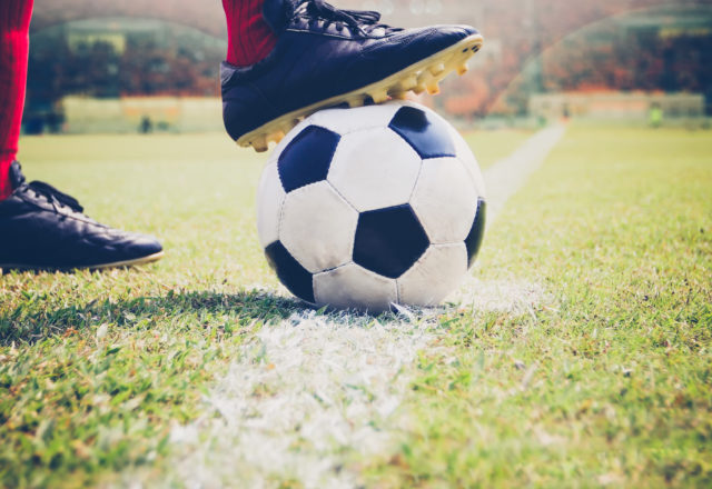 soccer or football player standing with ball on the field for Kick the soccer ball at football stadium